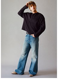 Model wearing black sweatshirt and blue jeans