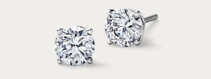 White gold round diamond stud earrings in four-prong setting.