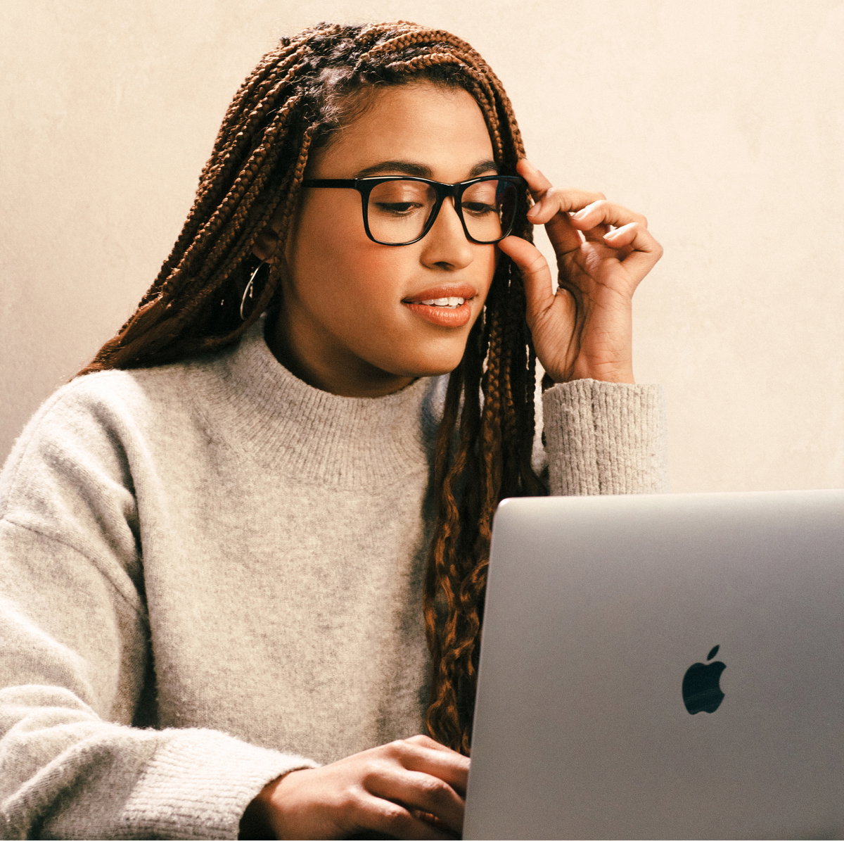 Woman wearing glasses using a laptop outdoors