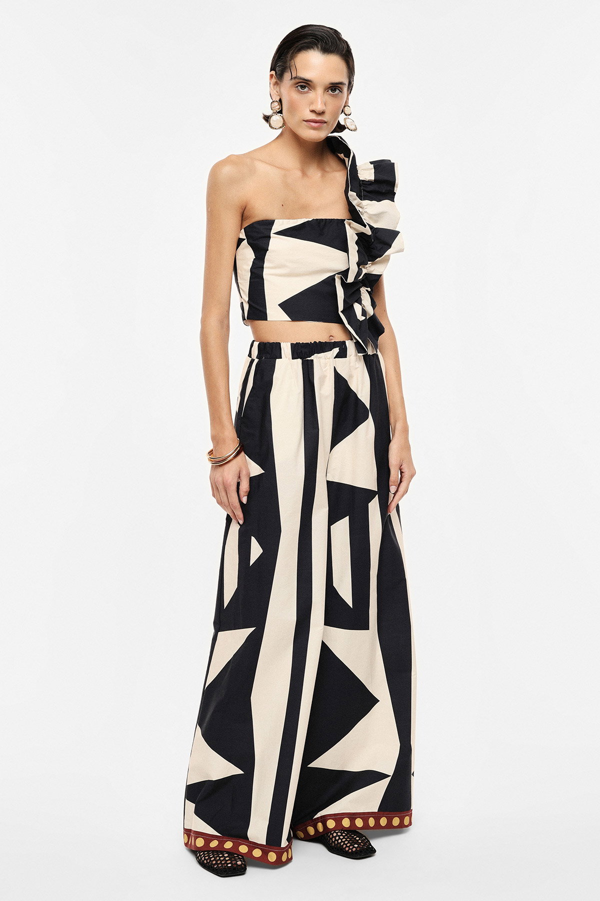 Woman modelling black-and-cream geometric one-shoulder ruffle crop top with matching wide-leg trousers