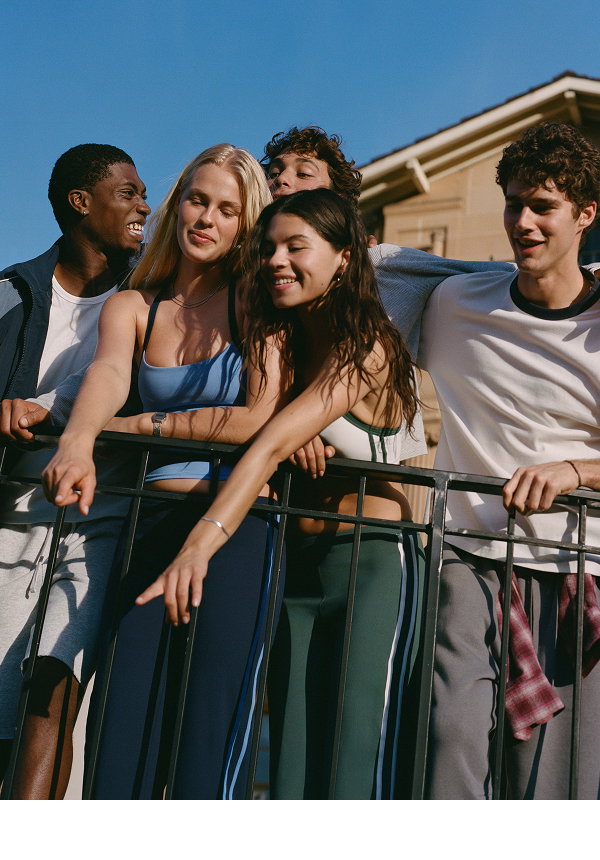 Five diverse young people smiling on a balcony together