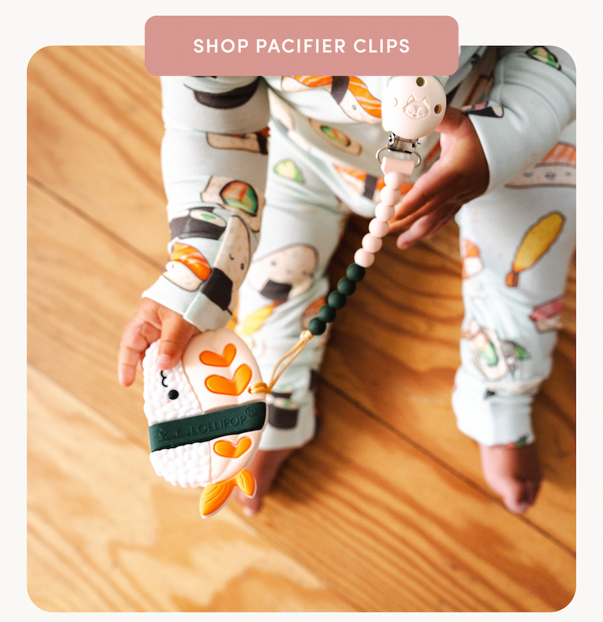 peach button with cream text on a photo of a baby holding a sushi teether and wearing a sushi print sleeper