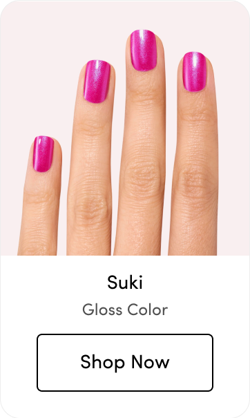 Close-up of manicured nails in a shimmery magenta-pink shade called 'Suki' with a 'Shop Now' button below, labeled 'Gloss Color.'