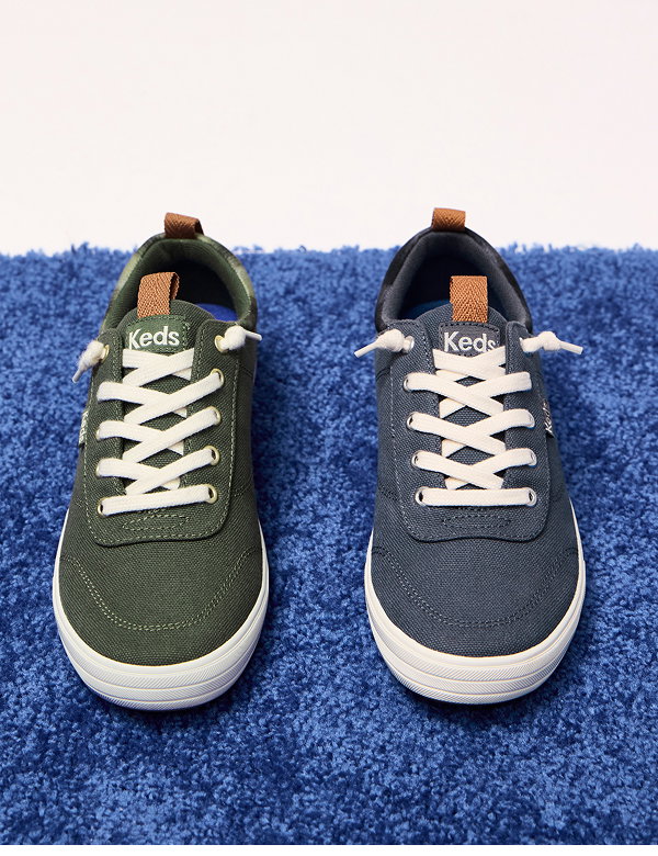 A blue carpet with the Center III Twill Ombre Plaid Collar Slip-On in olive on the left and the style in dark grey on the right. 