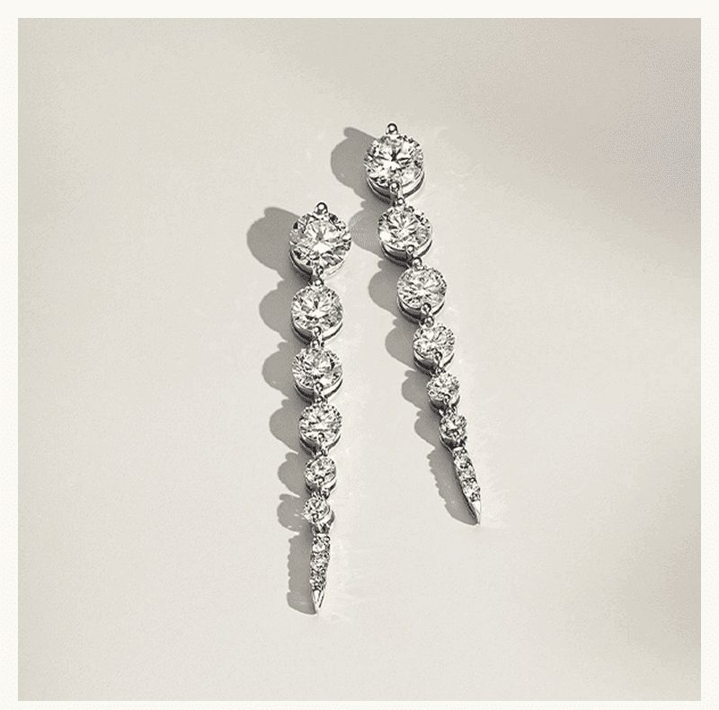 Alternating images of a pair of diamond hoop earrings and a pair of tapered diamond drop earrings.