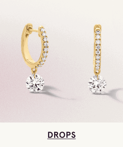 A pair of gold diamond hoop drop earrings. Click here to shop drops