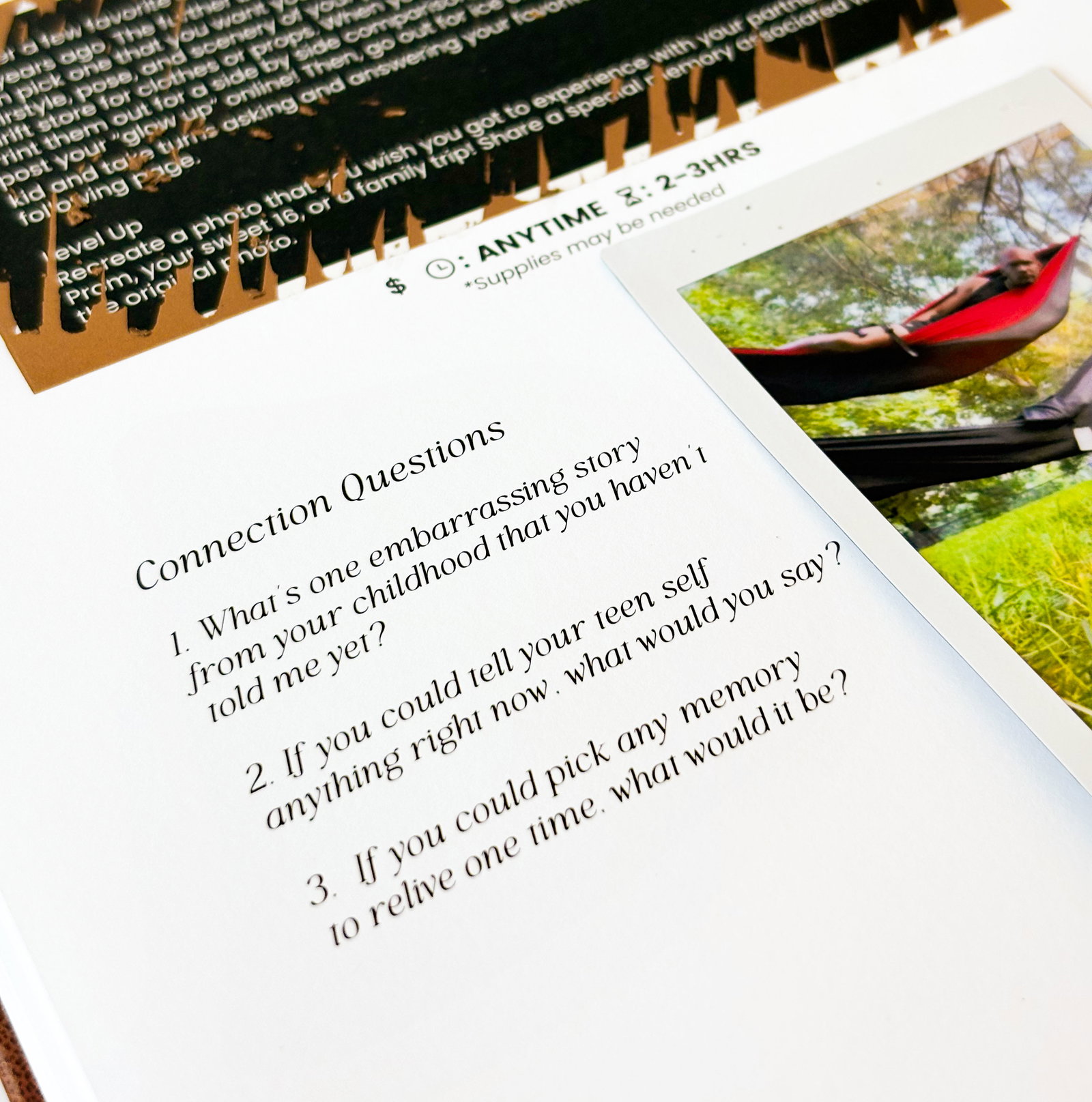 Close-up of a Couples Luxe journal spread featuring guided connection questions, a completed scratch-off adventure, a photo from the date, and icons showing cost, time of day, and estimated duration.