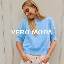 Lichtblauwe gebreide trui met korte puffmouwen en een geribde zoom, gecombineerd met lichtgekleurde high-waisted jeans. Soepele textuur.