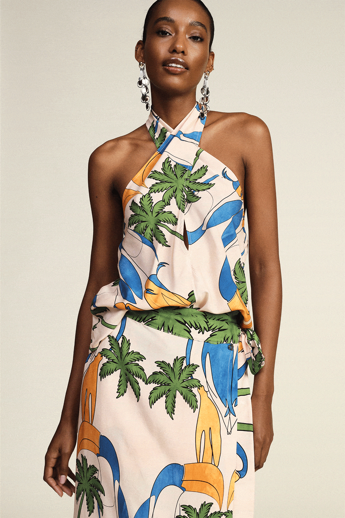 Four models in summer looks: tropical halter skirt; blue patterned backless dress; crochet top and shorts; pink tie-dye maxi