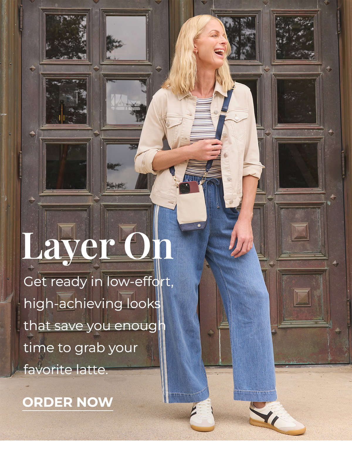 Woman models a beige jacket and wide leg jeans for a back to school outfit.