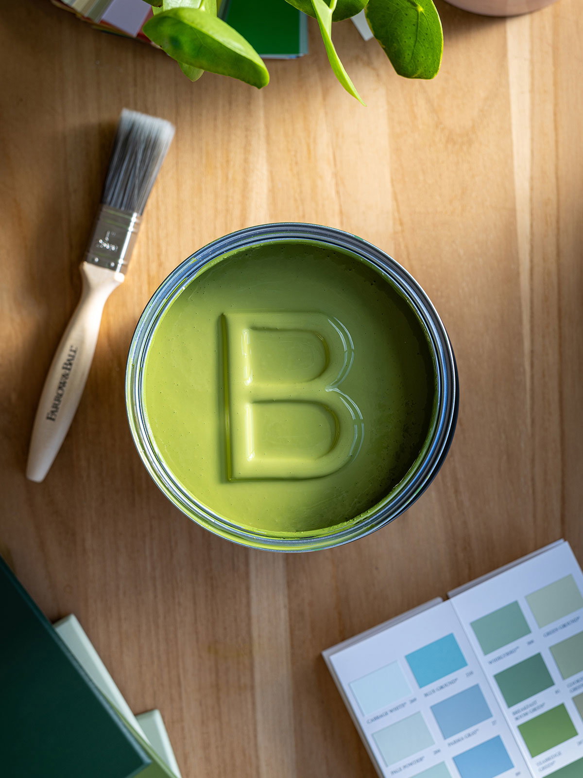 Overhead image of a tin of green paint with a B inside.