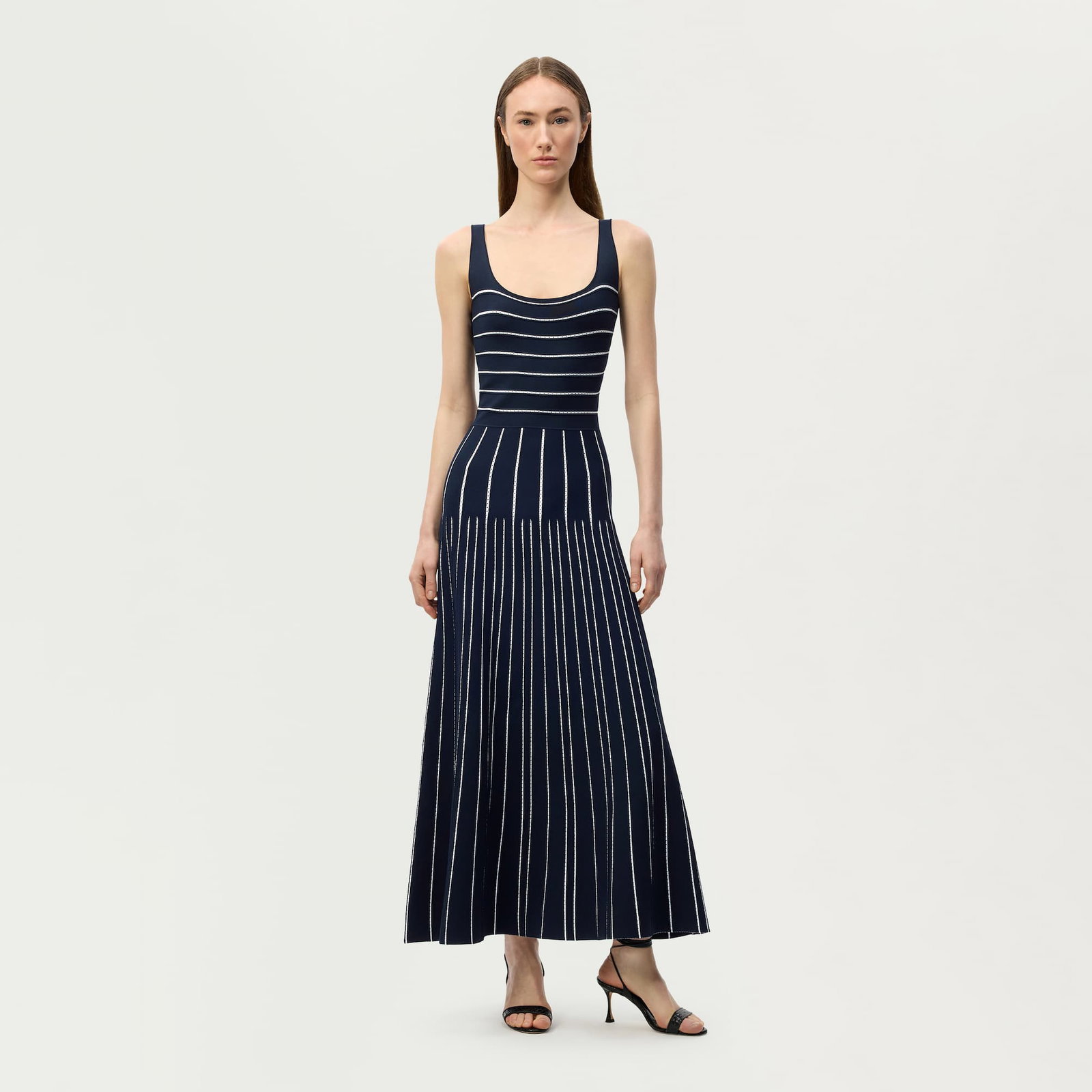 Editorial image of a model wearing the gemma dress in navy and white stripe.