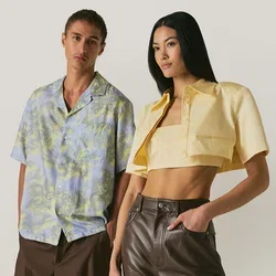 Giovane uomo e donna in piedi fianco a fianco, indossando abiti estivi casual e alla moda su uno sfondo beige semplice.