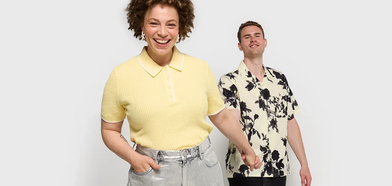 Geel geribde polo shirt met witte kraag, gecombineerd met zilveren wijde broek. Licht bloemen overhemd met korte mouwen in zwart en beige tinten.