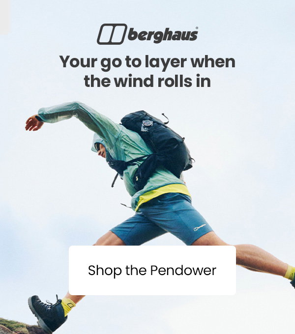 Person wearing a Berghaus lightweight jacket and backpack jumps between rocks outdoors, with the text “Your go to layer when the wind rolls in” and a “Shop the Pendower” call-to-action.