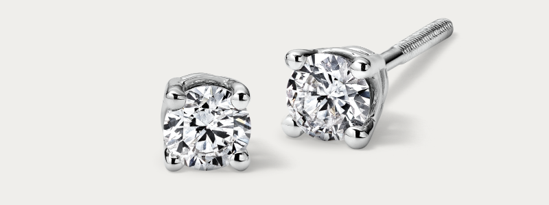 White gold round diamond stud earrings in four-prong setting.