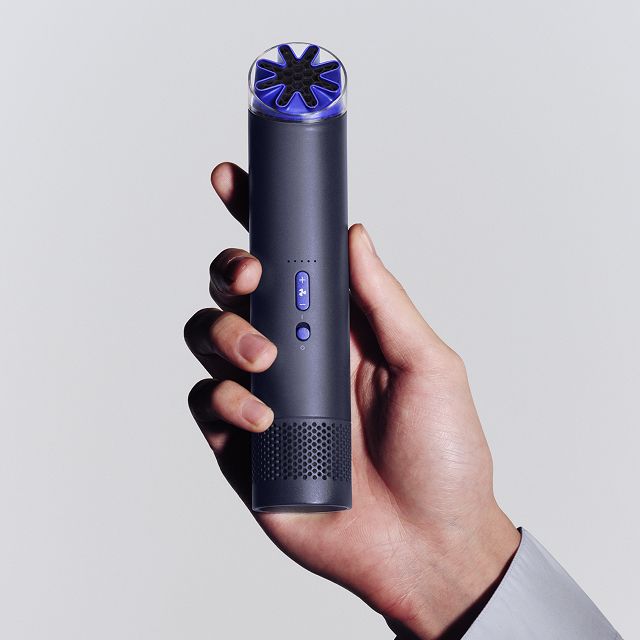 Dyson HushJet Mini Cool portable fan held in a hand.