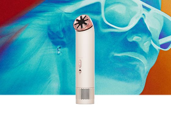 Dyson HushJet Mini Cool fan in Stone/Blush next to a model.