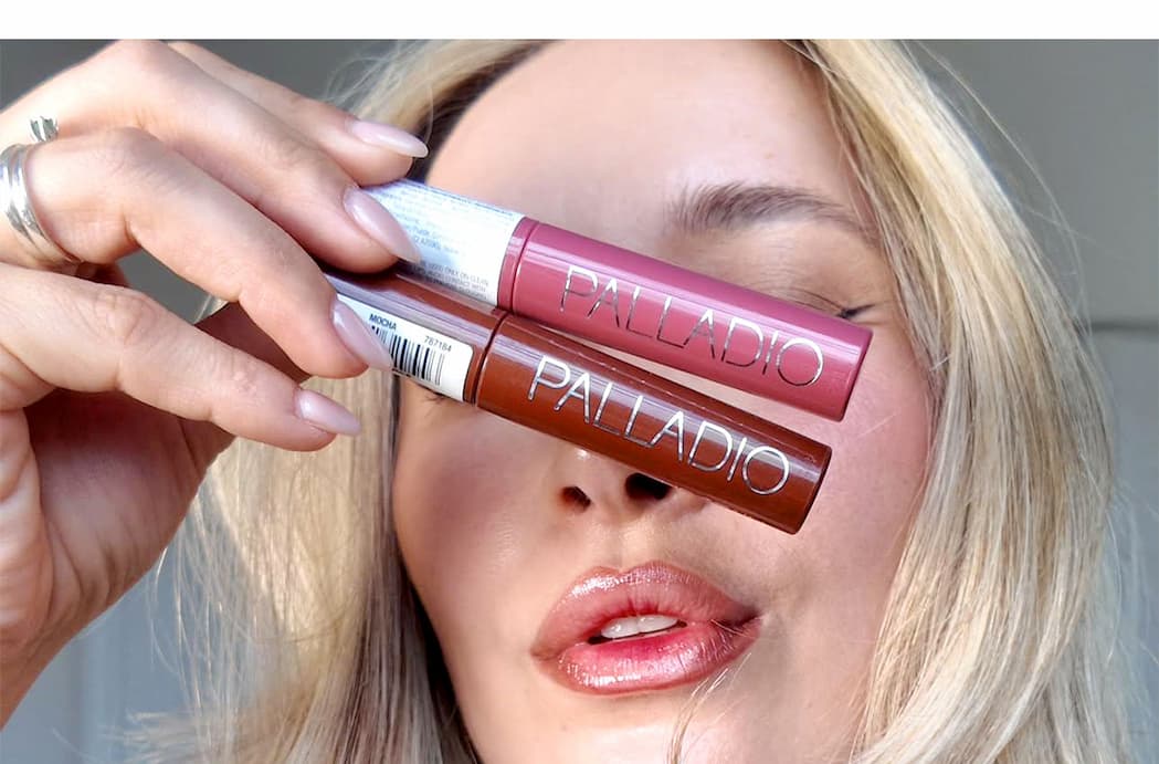 Beauty creator Larubiamaquilla holds two Palladio lip products while wearing a glossy neutral lip look.