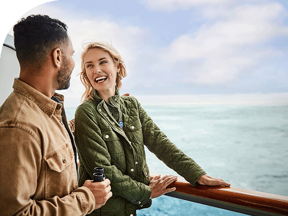 A couple looks out at the opens seas on a Princess ship