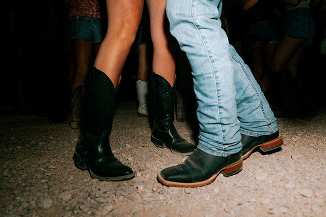 A man and a woman wearing Justin Bentrail boots in black while dancing.