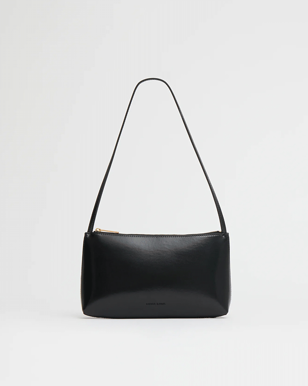 A slim strap, clean zip closure, and compact silhouette designed for everyday essentials.