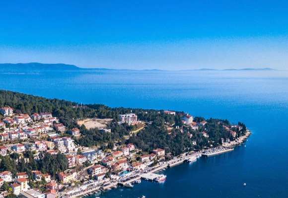 Coastal view of a picturesque town with colourful houses and a serene blue sea.