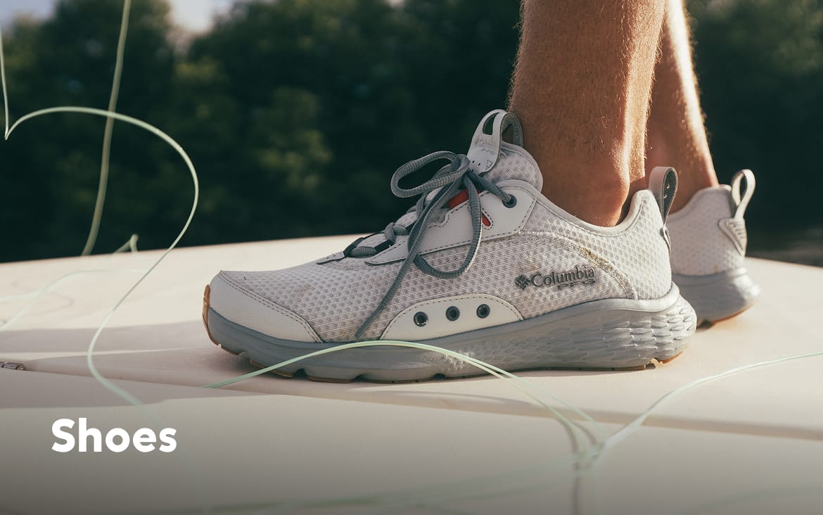 Close-up of an angler's white sneakers on a boat deck with text: Shoes