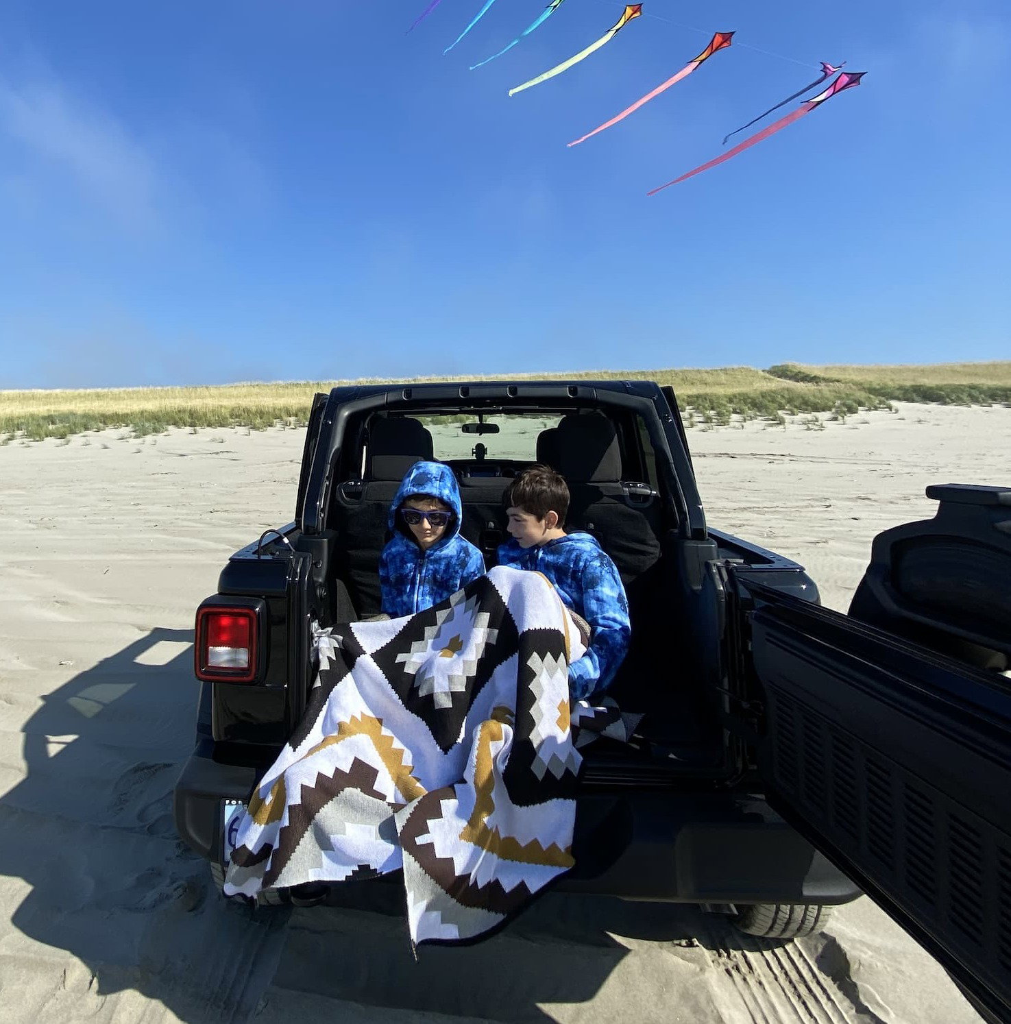 Boys in a Jeep covered in Seek & Swoon Homeland Throw