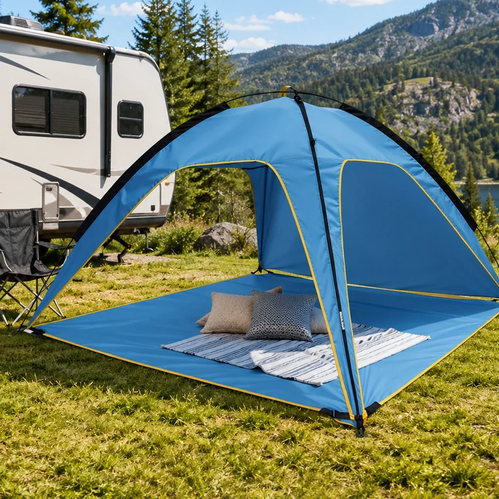 Blue pop-up tent with pillows set up next to RV in mountainous campground setting