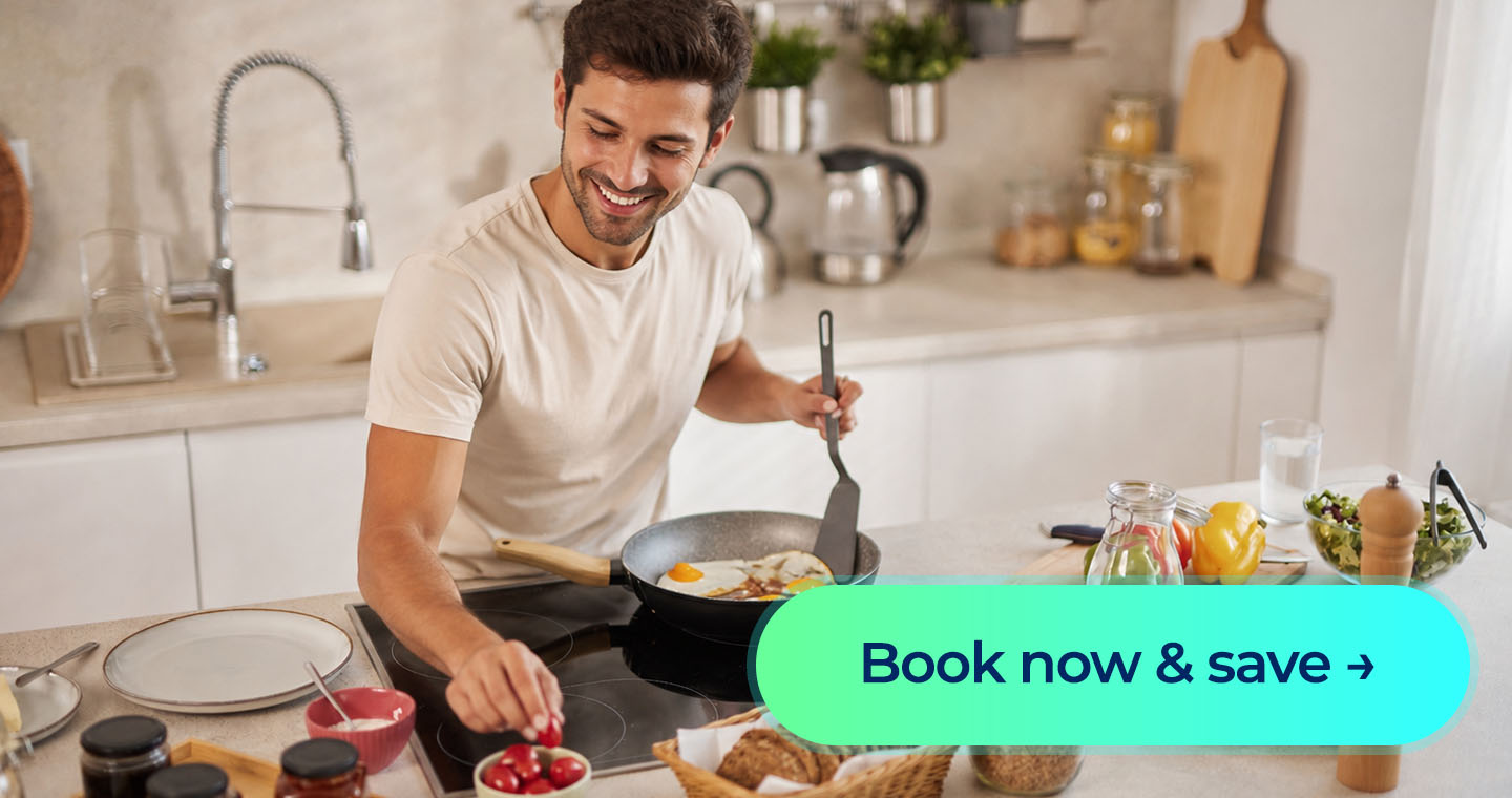 A smiling man cooks breakfast for his family, with a “Book now & save” call-to-action