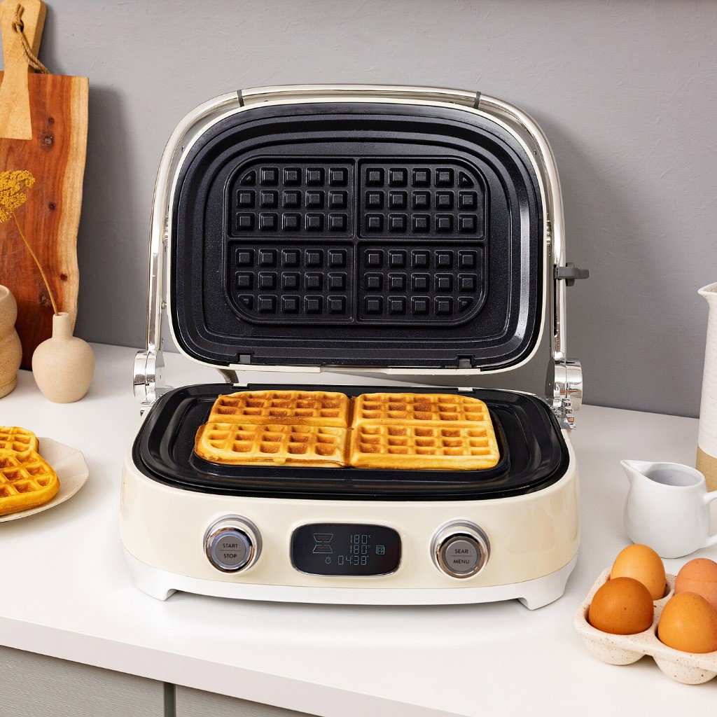 Grill Multiusos Smeg con placas para gofres y gofres recién hechos sobre una encimera de cocina