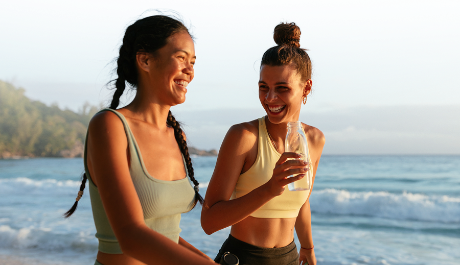 Two women walking near the ocean with waves