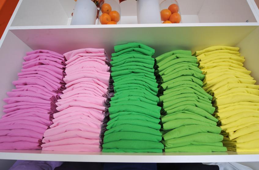bright colored t-shirts on a white shelf