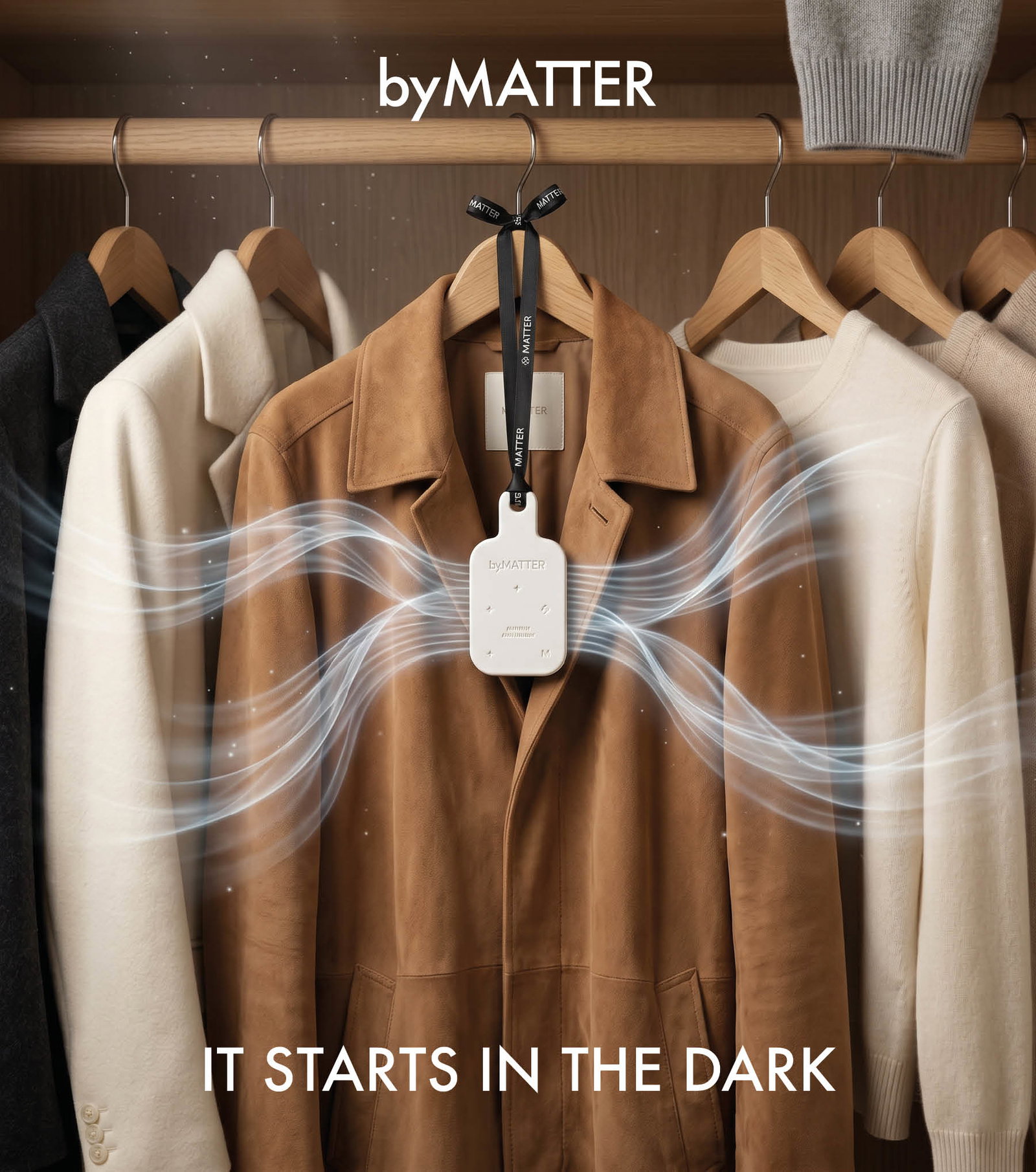 A Closet Guardian medallion hanging in a quiet wardrobe, beside folded cashmere.