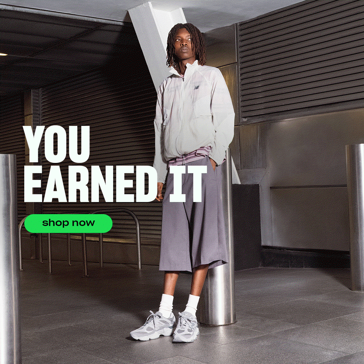 A hero gif image featuring a man wearing New Balance 2010 all grey style with text 'You earned it' and a Green Shop now button