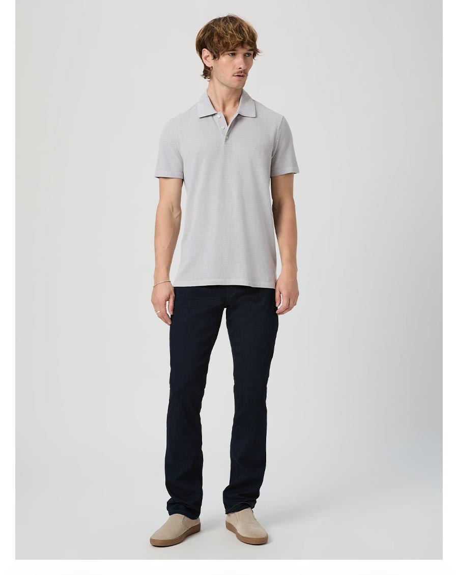 Man wearing a pair of dark wash straight leg jeans and a grey polo shirt