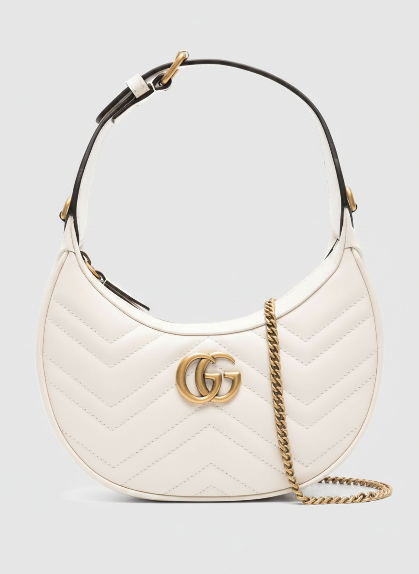 White Gucci Marmont crescent shoulder bag with gold GG logo and chain strap.