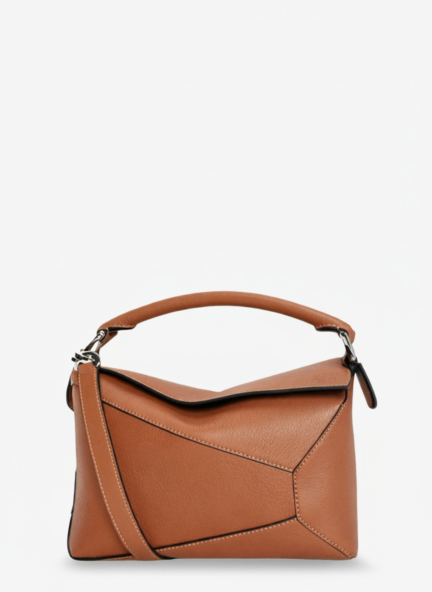 A brown leather handbag with a top handle and shoulder strap, on a white background.