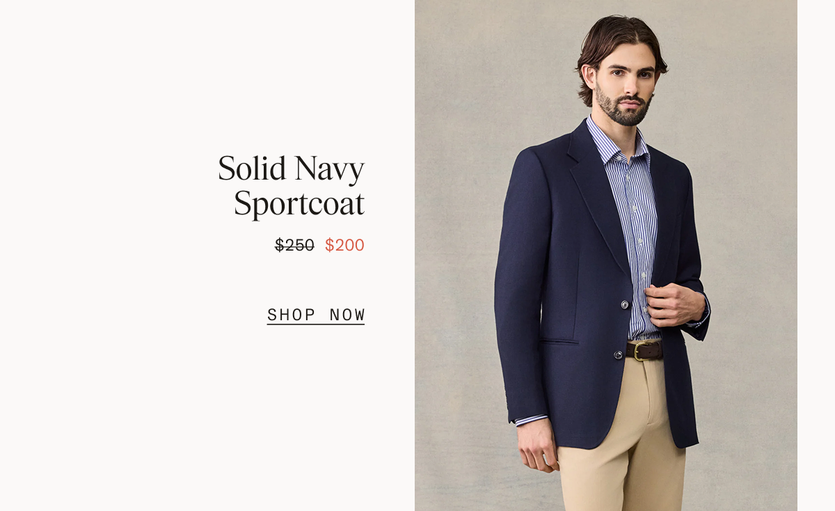 Man in a navy sportcoat over a blue and white striped shirt with tan trousers and a brown belt, standing with one hand resting on his lapel. Solid Navy Sportcoat $250 $200 SHOP NOW
