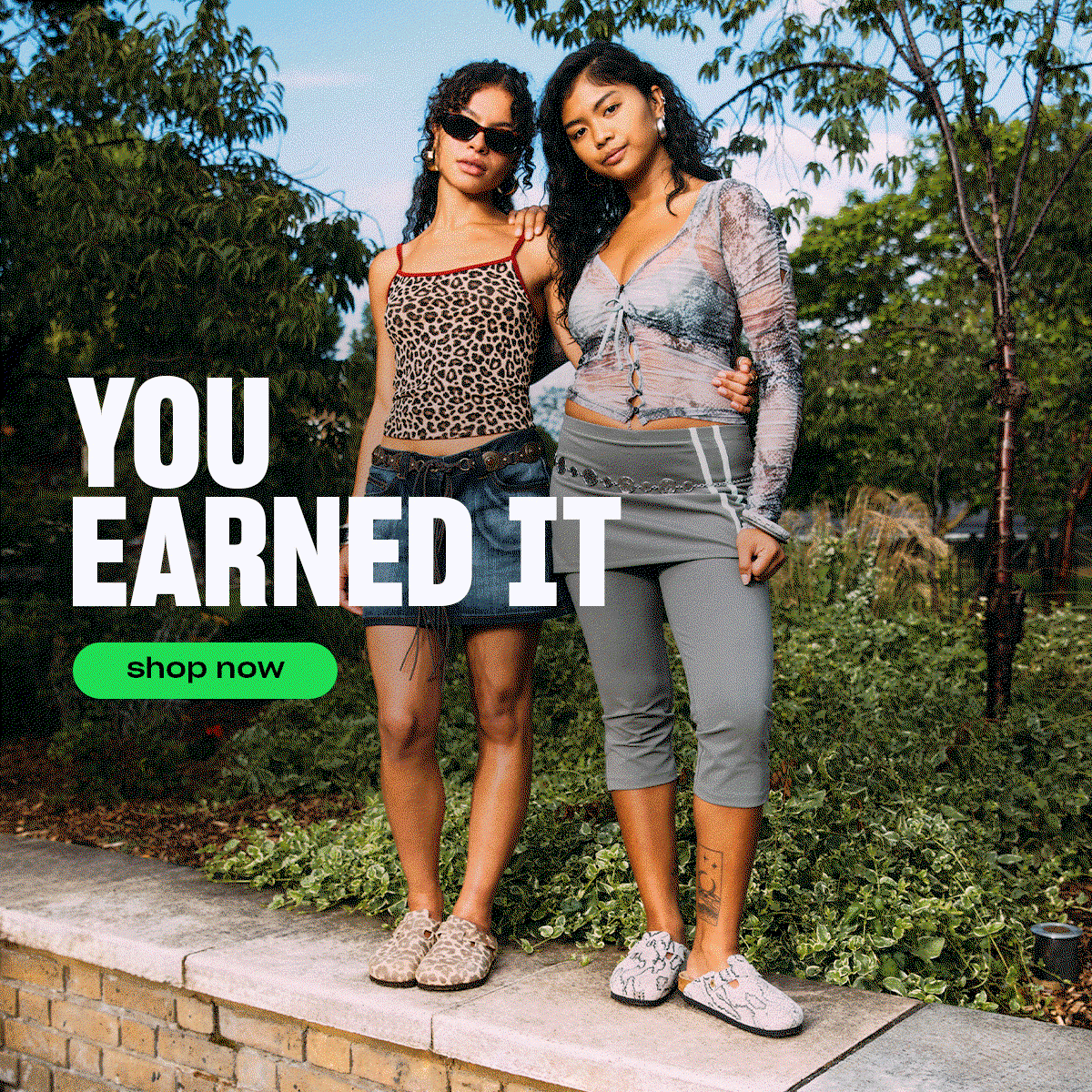 A hero image featuring two females in one image standing on a wall wearing BIREKNSTOCK Boston Clog print whilst two other females wear BIRKENSTOCK sandals with text 'You earned it' with a green shop now button.