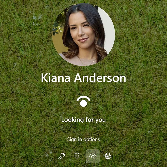 Shows the Windows login screen of a ‘Kiana Anderson.’ The screen shows ‘looking for you’ for a login using facial recognition.