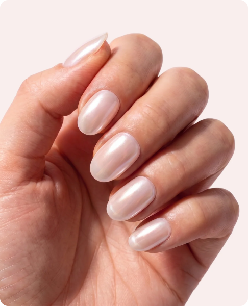 Close-up of a hand with round, shimmery pearlescent white manicured nails.