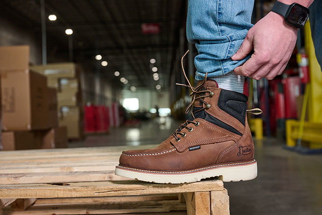 A manputting on the Bristol 6" Waterproof Steel Toe work boot in Hazel (Brown).