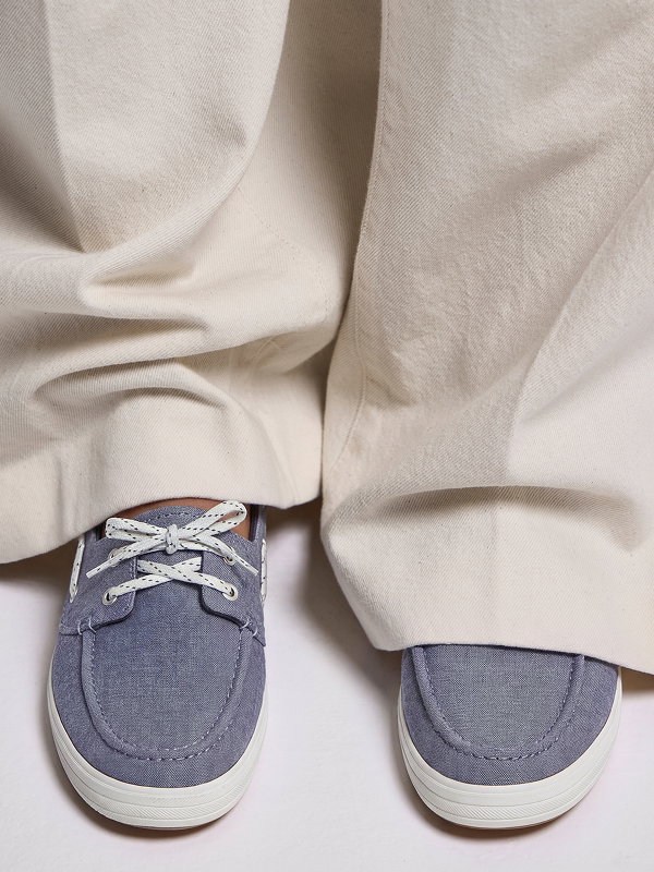 The Center III Boat Twill Slip-On in navy blazer peeking out from under beige wide-leg pants. 