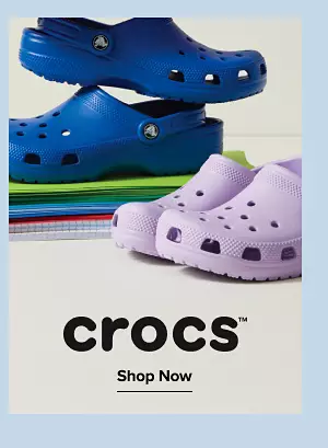 Crocs. Shop shoes. Two pairs of different colored crocs on school notebooks and pads.