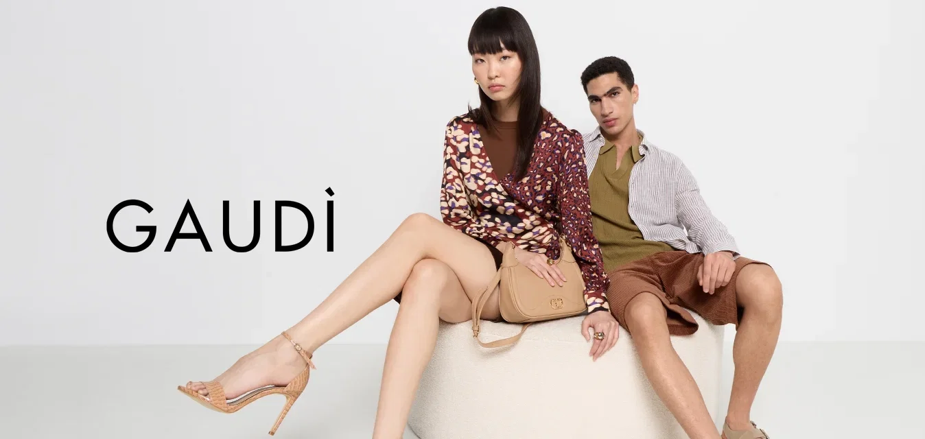 Deux modèles assis présentent un pouf circulaire beige clair. La femme porte un haut à manches longues à motifs et des talons beiges, tandis que l'homme est vêtu d'une chemise rayée et de shorts marron.