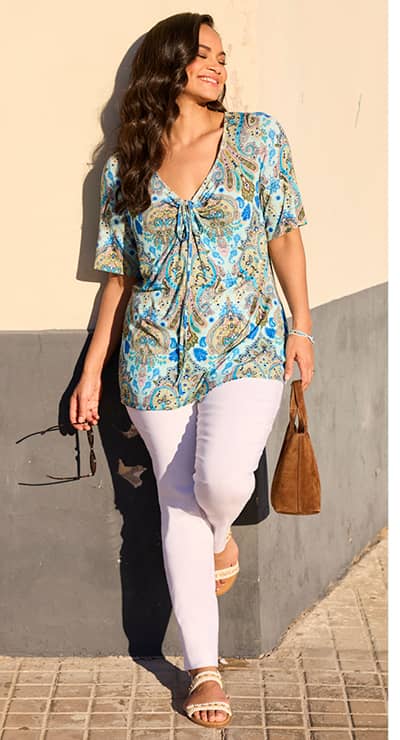 Ein Model trägt ein aquamarin-royalblau-gemustert Print-Shirt mit dekorativem Paisleyprint und eine weiße Hose