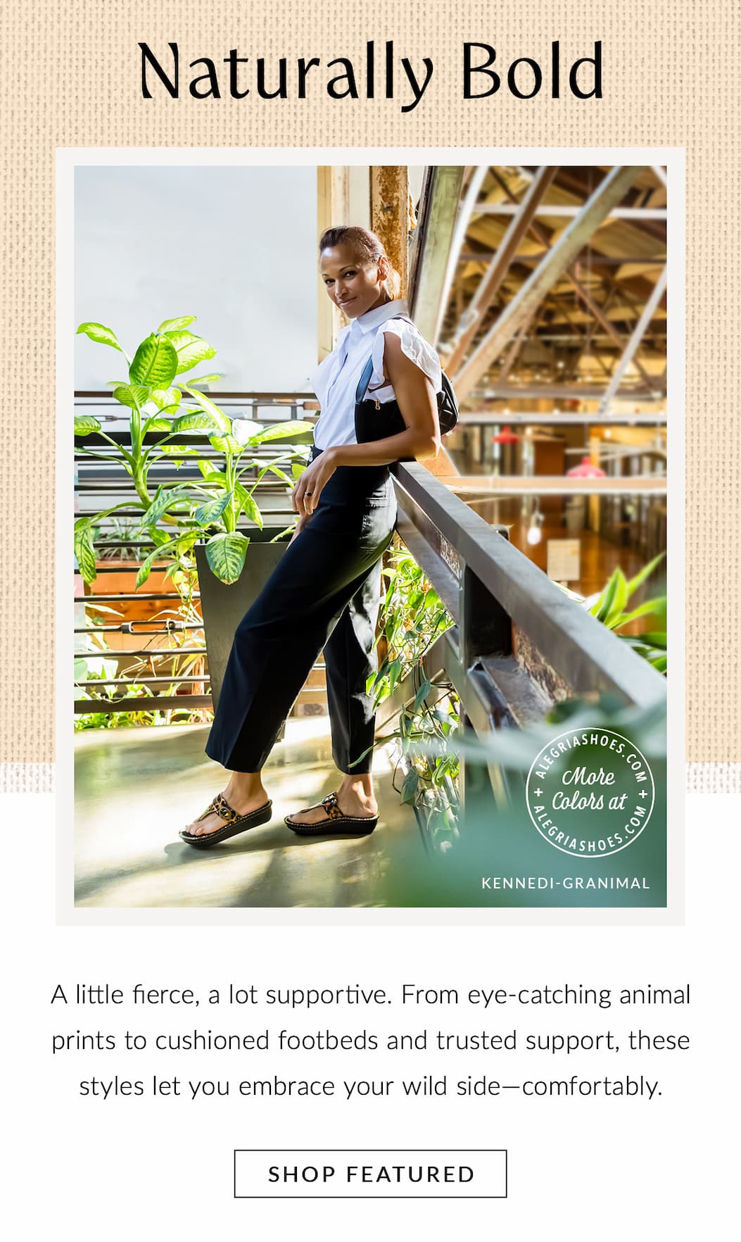 A woman wearing a white sleeveless top and black trousers leaning on a railing in a sunlit indoor balcony setting, modeling leopard print "KENNEDI-GRANIMAL" sandals. Headline above reads "Naturally Bold" with a "SHOP FEATURED" button below.
