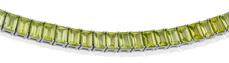A tennis bracelet featuring a green emerald cut peridot gemstones in silver.